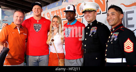 Semper Fidelis All-Americans P.J. Mbanasor, (center right), Cornerback at Hendrickson High School and Connor Lanfear, (second from left), Offensive Tackle at Jack C. Hays High School; Gunnery Sgt. Dario Hernandez, (far right), Maj. Matthew Peterson, (second from right), with Marine Corps Recruiting Station San Antonio; Erin Hogan, (left) and Ashley Kamrath, radio hosts with Austin radio 104.9 “The Horn,” pose for a photo after interview and jersey presentation at Scholtz Garten in Austin, Oct. 14, 2014. On front of hundreds of University of Texas at Austin fans who were at the event and thousa Stock Photo