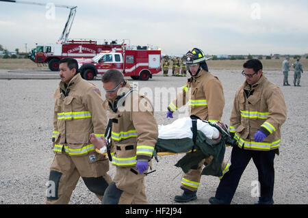 Emergency medical technicians and firefighters from Buckley Air Force Base transfer a simulated downed pilot to a pickup location during a Major Accident Response Exercise on base.  Members from the Colorado Air National Guard and the 460th Space Wing joined forces on Buckley Air Force Base to conduct a MARE training event. The exercise scenario was based on a simulated aircraft crash on base and evaluated the response efforts from the base fire department, hazmat clean-up team, security forces, as well as many others. MARE exercise 141009-Z-QD622-162 Stock Photo