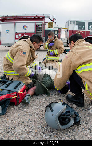 Emergency Medical Technicians from Buckley Air Force Base Carlos Hildago, Kory Macklin and Jon Gaetos  attend to a simulated downed pilot during a Major Accident Response Exercise on base.  Members from the Colorado Air National Guard and the 460th Space Wing joined forces on Buckley Air Force Base to conduct a MARE training event. The exercise scenario was based on a simulated aircraft crash on base and evaluated the response efforts from the base fire department, hazmat clean-up team, security forces, as well as many others. MARE exercise 141009-Z-QD622-084 Stock Photo