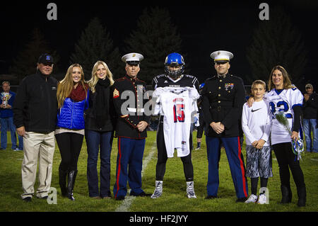 Drew Berger (center), an inside linebacker for the Coeur d’Alene High School Vikings and 17-year-old native of Coeur d’Alene, Idaho, stands alongside his family and receives his Semper Fidelis All-American Bowl jersey from Sgt. Alex Angle (left), a local Marine recruiter, and Capt. Ryan Sahlberg (right), the operations officer of Marine Corps Recruiting Station Seattle, before a game against the Lake City High School Timberwolves at Coeur d’Alene High School in Coeur d’Alene, Oct. 17, 2014. Berger is the sole Idaho player among approximately 100 student athletes from across the nation selected Stock Photo