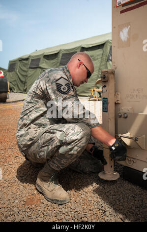 U.S. Air Force personnel from the Kentucky Air National Guard install leveling jacks on a mobile airfield operations center at Léopold Sédar Senghor International Airport, Dakar, Senegal, on Oct. 17, 2014, supporting Operation United Assistance. The operation enables the distribution of humanitarian aid and military equipment during the Ebola outbreak. Stock Photo