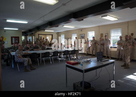 Sgt. Jose Estevez, a senior analyst with 2nd Battalion, 6th Marine Regiment, 2nd Marine Division briefs the group on the history of the battalion and the reason behind the unit wearing the French Fourragere before the ceremony held to award the French officers the fourragere aboard Marine Corps Base Camp Lejeune, N.C., Oct. 20, 2014. The French officers are being embedded with 2nd Bn., 6th Marines for the international exercise Bold Alligator. “We will accept them into the battalion, they’ll partner with us, they’ll go on missions with us, and they’ll observe our staff planning,” said Lt. Col. Stock Photo