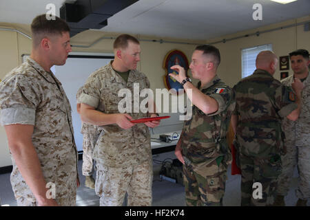 Captain Daniel F. Burns, a ground intelligence officer for 2nd Bn., 6th Marines, Capt. Kelby Breivogel, an information officer with 2nd Bn., 6th Marines, and Capt. Stephen Castillo, a French officer embedding with 2nd Battalion, 6th Marine Regiment, 2nd Marine Division, talk over future plans for the unit’s international exercise, Bold Alligator, during an award ceremony aboard Marine Corps Base Camp Lejeune, Oct. 20, 2014. “We will accept them into the battalion, they’ll partner with us, they’ll go on missions with us, and they’ll observe our staff planning. We’re really going to work hard to Stock Photo