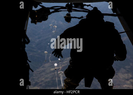 U.S. Marines with the Force Reconnaissance Detachment, 15th Marine Expeditionary Unit, conduct a static-line jump from an MV-22B Osprey during realistic urban training aboard Fort Hunter Liggett, Calif., Dec. 9, 2014. These Marines are part of the 15th MEU’s Maritime Raid Force. The purpose of RUT is to provide the MEU an opportunity to conduct training in unfamiliar environments in preparation for their upcoming deployment. (U.S. Marine Corps photo by Cpl. Anna Albrecht/Released) 15th MEU Marines conduct static line jumps 141209-M-SV584-034 Stock Photo