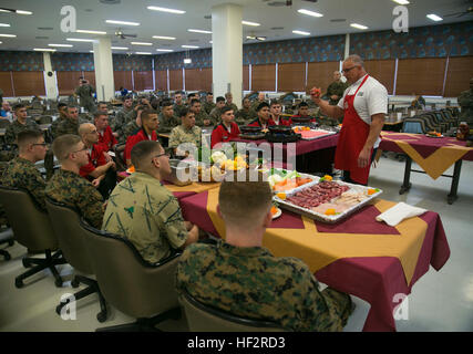 Chef Robert Irvine shows food service Marines with 4th Marine Regiment how to pre-cook vegetables Jan. 7 on Camp Schwab using a technique called blanching. Blanching is boiling vegetables and then plunging them into ice water before using them in a recipe. Blanching is used to whiten vegetables or partly or fully cook them. Irvine, an English celebrity chef and star of TV show, “Restaurant: Impossible,” came to Camp Schwab to cook with Marines attached to 4th Marine Regiment, 3rd Marine Division, III Marine Expeditionary Force. (U.S. Marine Corps photo by Lance Cpl. William Hester/ Released) C Stock Photo