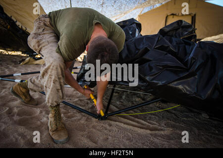 U.S. Marine Corps Lance Cpl. Benjamin A. McMahon, radio operator assigned to 4th Marine Regiment, conducts preventative maintenance on the frame of a tent during the setup of the Fire Support Coordination Center (FSCC) aboard Camp Wilson, Twentynine Palms, Calif., Jan. 17th, 2015. The Marines assigned to 4th Marine Regiment are participating in this Integrated Training Exercise (ITX) to act as a command element for the Special Purpose Marine Air-Ground Task Force (SPMAGTF), in which 2nd Battalion, 3rd Marine Regiment falls under in preparation of their upcoming Unit Deployment Program (UDP) to Stock Photo