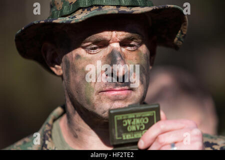 U.S. Marine Corps Capt. Scott M. Stafford, Executive Officer, Instructor Training Company, Advanced Infantry Training Battalion, School of Infantry-East applies camouflage face paint before conducting an 800m stalk on Camp Lejeune, NC, Jan. 21, 2015. Officers and Staff NCOs underwent training normally taught to snipers that required each Marine to advance 800 meters, set up, and identify a target all while remaining undetected. (U.S. Marine Corps photo by SOI-East Combat Camera, Lance Cpl. Andrew Kuppers/ Released) School of Infantry Officers and Staff NCOs undergo Scout Sniper Training 150121 Stock Photo