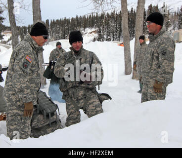 Lt. Dan Sweeney (middle), with 1st Battalion, 52nd Aviation, demonstrates to Army Chief of Staff Gen. Ray Odierno (left) and Maj. Gen. Michael Shields (right), U.S. Army Alaska commanding general, how to call for assistance when in the mountains of Alaska. Soldiers assigned to U.S. Army Alaska at the Northern Warfare Training Center teach Sweeney and other students mountaineering and cold-weather skills to help them be “Arctic Tough” and operate in the Army’s northernmost command. USARAK specializes in partnership and rapid deployment across the Pacific and boasts the Army’s premier high-altit Stock Photo