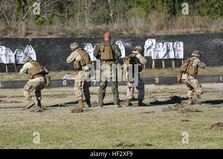 A Critical Skills Operator with 3rd Marine Special Operations Battalion, U.S. Marine Corps Forces Special Operations Command, watches as Marines with 2nd Combat Engineer Battalion, 2nd Marine Division, fire M4 carbine rifles at a range here, Feb. 10, 2015. Marines with 3rd MSOB participated in RAVEN 15-03, a 10-day realistic military training exercise to enhance the battalion’s readiness for worldwide support to global security. Marines with 2nd CEB played the role of a partner nation force during the exercise. (Official U.S. Marine Corps photo by GySgt. Josh Higgins/released) Gulf Coast regio Stock Photo