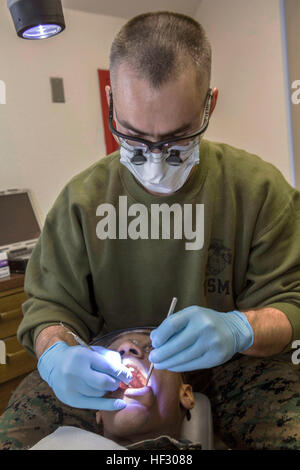 U.S. Navy Lieutenant Dustin A. Bond, with 22nd Dental Company, 2nd Dental Battalion (2nd Den Bn), 2nd Marine Logistics Group (2nd MLG), performs an oral cleaning at Quantico, Virginia, Feb. 24, 2015. 2nd Den Bn provided support to 1st Battalion, 8th Marine Regiment, 2nd Marine Division, and 2nd Transportation Support Battalion, 2nd MLG during a Deployment For Training (DFT) exercise. (U.S. Marine Corps photo by Cpl. Desire M. Mora/ Released) US Marines receive dental treatment during Deployment For Training exercise 150224-M-TG562-018 Stock Photo