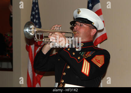 Gunnery Sgt. Michael Flaningam, a trumpet player in the 1st Marine Division Band, I Marine Expeditionary Force, plays taps in memory of fallen Marines during the Iwo Jima Commemorative Banquet for the 70th Anniversary of the Battle of Iwo Jima at Marine Corps Base Camp Pendleton, Calif., March 7. The evening included a sunset memorial, 21-gun salute, banquet and a video message for veterans from Commandant of the Marine Corps General Joseph Dunford. “Your legacy is the young men and women who use your example of courage and commitment to inspire them to confront and overcome the challenges tha Stock Photo