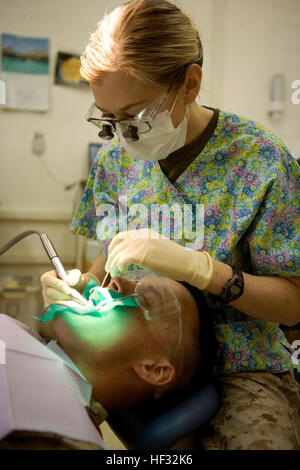 090626-M-1609K-009 AL ASAD, Iraq (May 26, 2009) Lt. Corinne C. Devin, from Las Vegas, Nev. deployed with Combat Logistics Battalion-7 (CLB-7), performs a composite filling procedure on a patient at the Wing Medical Clinic. CLB-7 is deployed as part of Multi National Forces-West supporting Operation Iraqi Freedom in Al Anbar Province, Iraq. (U.S. Marine Corps photo by Lance Cpl. John A. Krake/Released) US Navy 090626-M-1609K-009 Lt. Corinne C. Devin, from Las Vegas, Nev. deployed with Combat Logistics Battalion-7 (CLB-7), performs a composite filling procedure on a patient at the Wing Medical C Stock Photo