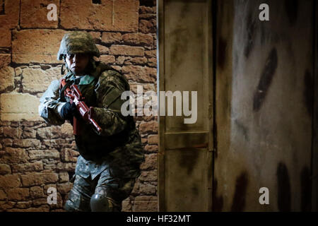 U.S. Army Capt. Joannie Floyd exits a doorway during a Modern Army Combatives Program (MACP) training scenario at the New Jersey National Guard Training and Training Technology Battle Lab at Joint Base McGuire-Dix-Lakehurst, N.J., March 11, 2015. The Battle Lab features numerous combat simulators, as well as an indoor urban area for ground combat training. Fields is assigned to the 1-314th Infantry Battalion. (U.S. Air National Guard photo by Tech. Sgt. Matt Hecht/Released) MACP level II training at Battle Lab 150311-Z-NI803-368 Stock Photo