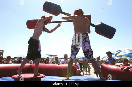 Contestants battle it out in a pugil stick arena during the Ken Grody Ford Beach Bash 2009 at Del Mar Beach, July 4. It was hosted by Marine Corps Community Services Camp Pendleton, and representatives from Ken Grody Ford attended the event passing out cards for a chance to win a 2007 Ford Focus. There were many activities such as volleyball tournaments, temporary tattoo parlors and climbing walls, in addition to the many free interactive games available for all age groups. Service Members Celebrate Independence Day With Beach Bash DVIDS186077 Stock Photo