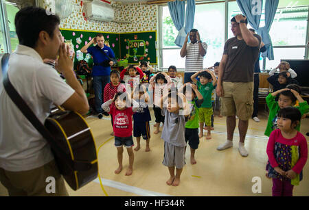 Marines with 3rd Intelligence Battalion dance and sing to “Head, Shoulders, Knees and Toes” during the Play in English Program March 18 at Suginoko Preschool in Kin Town, Okinawa. The Marines visit the preschool monthly to teach English as well as get to know their neighbors. The children learned how to say the Marines names and how they feel. The day ended with free time to play with the volunteers. The Marines are with 3rd Intel Battalion, III Marine Expeditionary Force Headquarters Group, III MEF. (U.S. Marine Corps photo by Cpl. Rebecca Elmy/Released) Marines Break Through Language Barrier Stock Photo