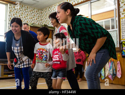 Sgt. Desiree Guerrero, right, from San Antonio, Texas, and Aoi Shingaki hold the hands of a preschoolers March 18 during the Play in English Program at the Suginoko Preschool in Kin Town, Okinawa. Marines from 3rd Intelligence Battalion on Camp Hansen spent the day teaching preschoolers English along with playing games and singing songs. Shingaki is the assistant care giver at the Suginoko Preschool. Guerrero is an intelligence specialist with 3rd Intel Bn, III Marine Expeditionary Force Headquarters Group, III MEF. (U.S. Marine Corps photo by Cpl. Rebecca Elmy/Released) Marines Break Through  Stock Photo