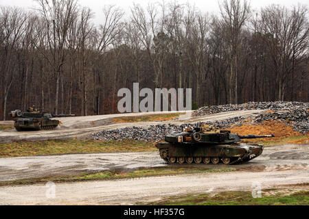 Two M1A1 Abrams tanks with 2nd Tank Battalion, 2nd Marine Division leave their defensive position on the platoon gunnery range and prepare to close with and engage the enemy down range at Fort Pickett, Va., March 25-28, 2015.  Four Marines in each tank conducted the platoon gunnery range for qualification, in which they shot from a defensive position, tactically moved up toward the simulated enemy and withdrew for a counter-attack when the enemy engaged the tanks.  (U.S. Marine Corps photo taken by Cpl. Alexander Mitchell/released) 2nd Tanks conduct MCCRE 150327-M-ML847-570 Stock Photo