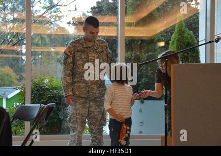 Army Sgt. Marc Hillhouse, administrative sergeant and an 11-year Active Guard Reservist of the North Carolina National Guard's E Company, 1-130th Attack Reconnaissance Battalion, and his 6-year-old daughter Millie take a moment to get a shot of a playhouse donated by Glaxo Smith Kline Institute (GSK) and Habitat for Humanity organizations in Research Triangle Park, N.C., earlier this month. The gift, a life-sized playhouse, was an early birthday present for Millie and was part of GSK's donation in recognition of Year of the Child 2013. Five other charity organizations to include Genesis Home i Stock Photo