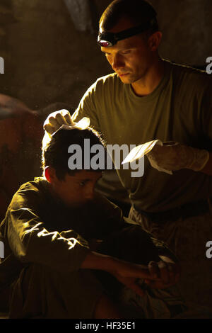 090715-M-2581P-888 HELMAND PROVINCE, Afghanistan (July 15, 2009) Hospital Corpsman 2nd Class Brian Saudau, from Mitchell, South Dakota assigned to 1st Battalion, 5th Marine Regiment, treats a local Afghan boy for a laceration to his head at Patrol Base Jaker in the Nawa District of Helmand Province in Afghanistan. (U.S. Marine Corps photo photo by Lance Cpl. James B. Purschwitz/Released) US Navy 090715-M-2581P-888 Hospital Corpsman 2nd Class Brian Saudau, from Mitchell, South Dakota assigned to 1st Battalion, 5th Marine Regiment, treats a local Afghan boy for a laceration to his head Stock Photo