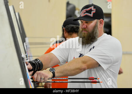 Retired Army Sgt. 1st Class Brian Lowen checks his shot group during archery training at MacDill Air Force, Fla., April 28, 2015.  Veteran and active duty special operations forces will participate in archery, track and field, siting-volleyball, wheelchair-basketball, swimming and shooting competitions during the 2015 DoD Warrior Games at Marine Corps Base, Quantico, in June. (Photo by Marine Staff Sgt. Jayson Price) Team SOCOM trains for DOD Warrior Games 2015 150428-M-WE418-005 Stock Photo