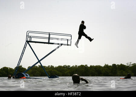 Marine Corps Cpl. Timothy Dobson jumps feet first off a high dive during a water obstacle course in the Sadoum River, recently. Alongside Senegalese Commandos, Nigerian Navy Special Boat Service operators and fellow Marines of second platoon, Ground Combat Element, Security Cooperation Task Force, Africa Partnership Station 2011, Dobson has conducted several engagements aligned with the APS-11 mission of theater security cooperation and partnered military-to-military exchanges. (U.S. Marine Corps photo by Lance Cpl. Timothy L. Solano) APS-11 Marines, Senegalese commandos maneuver through river Stock Photo