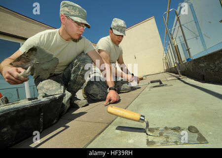 Air National Guard personnel from the 142nd Fighter Wing Civil Engineer Squadron install a new exterior tile floor at a medical facility in Mangalia, Romania, under U.S. European Command’s Humanitarian Civic Assistance program, aimed at improving critical infrastructure and living conditions for the civilian population. Stock Photo