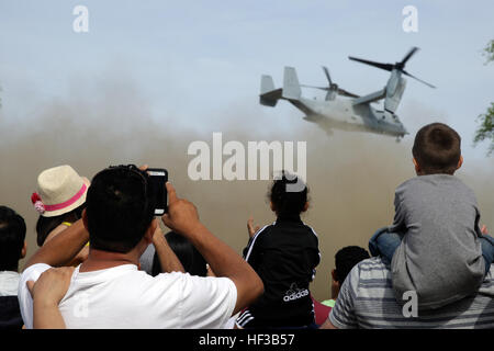 A young boy sits on his father’s shoulders and watches as an MV-22 Osprey takes off after aerial showcase at Playland Amusement Park in Rye, New York, May 24, 2015.  The company provided the local community to see the capabilities of the sea services as part of Fleet Week New York 2015.  (U. S. Marine Corps photo taken by Cpl. Alexander Mitchell) 1-6 Marines showcase sea service capabilities 150524-M-ML847-390 Stock Photo