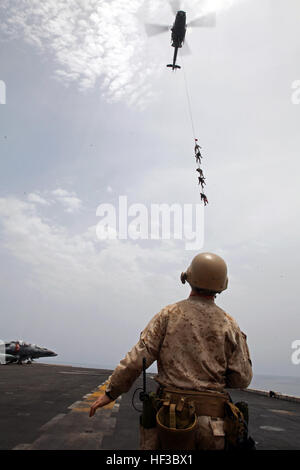 150528-M-QZ288-045: GULF OF ADEN (May 28, 2015) Reconnaissance Marines with the 24th Marine Expeditionary Unit’s Maritime Raid Force, sourced from Force Reconnaissance Company, 2nd Reconnaissance Battalion, are recovered via a special patrol insertion/extraction line from a UH-1Y Huey onto the amphibious assault ship USS Iwo Jima (LHD 7) after conducting helo-cast training in the Gulf of Aden, May 28, 2015. The Huey belongs to Marine Medium Tiltrotor Squadron 365 (Reinforced), 24th MEU. The 24th MEU is embarked on the Iwo Jima Amphibious Ready Group and deployed to maintain regional security i Stock Photo