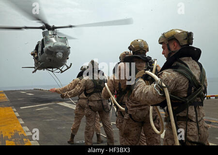 150528-M-QZ288-079: GULF OF ADEN (May 28, 2015) Reconnaissance Marines with the 24th Marine Expeditionary Unit’s Maritime Raid Force, sourced from Force Reconnaissance Company, 2nd Reconnaissance Battalion, are recovered via a special patrol insertion/extraction line from a UH-1Y Huey onto the amphibious assault ship USS Iwo Jima (LHD 7) after conducting helo-cast training in the Gulf of Aden, May 28, 2015. The Huey belongs to Marine Medium Tiltrotor Squadron 365 (Reinforced), 24th MEU. The 24th MEU is embarked on the Iwo Jima Amphibious Ready Group and deployed to maintain regional security i Stock Photo