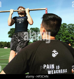 Staff Sgt. David Castro counts the pull-ups of Eric Duhamel, a running back for the East Bridgewater High School freshman football team of East Bridgewater, Mass., during the beginning hours of the Semper Fidelis All-American Camp at St. John Preparatory High School in Danvers, Massachusetts, June 7. Nearly 200 top football players from high schools throughout the New England states, including New York, Pennsylvania and New Jersey, received training from the NFL and college football coaches while fighting for a spot to play in the 2016 Semper Fidelis All-American Bowl game in California. Castr Stock Photo