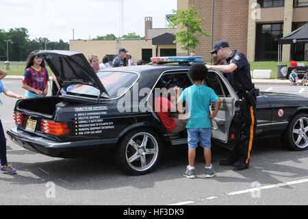 An officer from the Egg Harbor Township Police Department speaks to fifth-grade students from Dr. Joyanne D. Miller School, Egg Harbor Township, N.J., during the 19th annual DARE day graduation on June 19, 2015. Members from the New Jersey Air National Guard's 177th Fighter Wing came together with Egg Harbor Township Police, emergency medical services, Atlantic County SWAT, West Atlantic City Volunteer Fire Company, and Cardiff Volunteer Fire Company to celebrate the fifth-grade students' completion of the DARE program. (U.S. Air National Guard photo by Airman 1st Class Amber Powell/Released)  Stock Photo