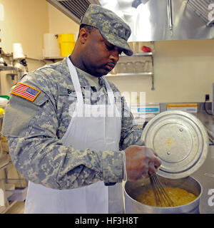 Spc. Jermaine Burns, of Indianola, Miss., assigned to the 1387th Quartermaster Company, Mississippi Army National Guard (MSARNG) stirs spicy brown rice pilaf during a food service workshop conducted by the Culinary Arts Institute at the Mississippi University for Women on July 23, 2015. The eighth-annual workshop provided MSARNG food service specialists with lecture and hands-on skill development designed not only to focus on the basics, but also to introduce advanced techniques relevant to Army food service programs. More than 75 Soldiers have been trained since the program’s inception in 200 Stock Photo