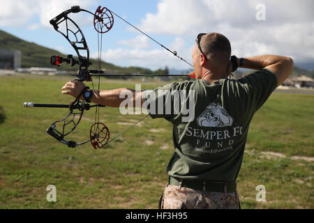 Staff Sgt. Charles Amerson, a section leader with the Wounded Warrior Battalion West-Detachment Hawaii and Tampa, Fla., native, draws back on his bow at the archery range aboard Marine Corps Base Hawaii, July 23, 2015. Every Tuesday and Thursday, service members with the detachment participate in activities such as archery, swimming, track, shooting and cycling as part of the Warrior Athletic Reconditioning Program. The purpose of WARP is to help service members find hobbies and help maintain mental and physical fitness as they go through treatment and recovery. The mission of Marine Corps Bas Stock Photo