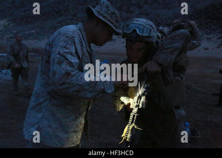 ARTA BEACH, Djibouti (July 26, 2015) U.S. Marine Gunnery Sgt. Michael Ramirez, left, ensures Lance Cpl. George Camden weapon is free of rounds after establishing a battle-sight zero. Ramirez is  a platoon sergeant and Camden is a vehicle driver, both with Combined Anti-Armor Team 1, Weapons Company, Battalion Landing Team 3rd Battalion, 1st Marine Regiment, 15th Marine Expeditionary Unit. Elements of the 15th MEU are ashore in Djibouti for sustainment training to maintain and enhance the skills they developed during their pre-deployment training period.  The 15th MEU is currently deployed in s Stock Photo