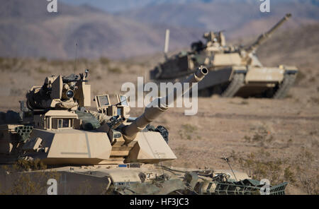 Soldiers from D Company, 3rd Battalion, 116th Cavalry Brigade Combat Team (CBCT), Oregon Army National Guard, maneuver M1A2 Abrams tanks toward an obstacle breach operation during a company live fire exercise, Aug. 16, at the National Training Center, Fort Irwin, Calif. The 116th CBCT is participating in battle simulation scenarios composed of more than 5,200 Soldiers with National Guard units from 10 states, the U.S. Army Reserve and active duty U.S. Army Soldiers. (Photo by Maj. W. Chris Clyne, 115th Mobile Public Affairs Detachment) National Guard conducts live fire at NTC 150816-Z-ZJ128-00 Stock Photo