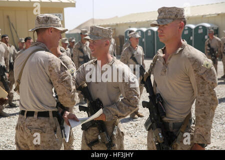 Corporal Taylor Cross, center, a native of Cedar Falls, Iowa, shakes hands with Capt. Scott Stewart, commanding officer, Weapons Company, 1st Battalion, 7th Marine Regiment, after being promoted to corporal aboard Camp Leatherneck, Afghanistan, June 1, 2014. Cross, an anti-tank missileman with Weapons Co., and 20 other lance corporals with the battalion were promoted, June 1 and 2. (U.S. Marine Corps photo by Cpl. Joseph Scanlan / released) Marines promoted in Helmand province, Afghanistan 140605-M-OM885-447 Stock Photo