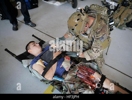 A New York Air National Guard pararescue jumper works on a  simulated patient during a casualty drill conducted at F.S. Gabreski Air National Guard Base, at Westhampton Beach, N.Y., on Aug. 25, 2015. The drill was conducted so that members of the 103rd Rescue Squadron, a part of the 106th Rescue Wing, could evaluate technology designed to help them monitor patients in the field. The computer notebook being used as part of the system can be seen on the patient's chest. The technology is being developed as part of the Air Force BATMAN program which seeks to put useful, wearable computer systems  Stock Photo