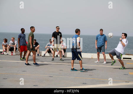 GULF OF ADEN (Aug. 29, 2015) U.S. Marines and Sailors from the 15th Marine Expeditionary Unit and Essex Amphibious Ready Group play soccer during a steel beach picnic aboard the amphibious transport dock ship USS Anchorage (LPD 23). Elements of the 15th MEU are embarked aboard the Anchorage, which is part of the ESX ARG, and is deployed in support of maritime security operations and theater security cooperation efforts in the U.S. 5th Fleet area of operations. (U.S. Marine Corps photo by Sgt. Steve H. Lopez/Released) US Marines, Sailors enjoy steel beach picnic 150829-M-TJ275-028 Stock Photo