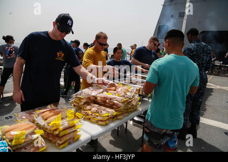 GULF OF ADEN (Aug. 29, 2015) U.S. Marines and Sailors from the 15th Marine Expeditionary Unit and Essex Amphibious Ready Group fill their plates with food at a steel beach picnic aboard the amphibious transport dock ship USS Anchorage (LPD 23). Elements of the 15th MEU are embarked aboard the Anchorage, which is part of the ESX ARG, and is deployed in support of maritime security operations and theater security cooperation efforts in the U.S. 5th Fleet area of operations. (U.S. Marine Corps photo by Sgt. Steve H. Lopez/Released) US Marines, Sailors enjoy steel beach picnic 150829-M-TJ275-032 Stock Photo