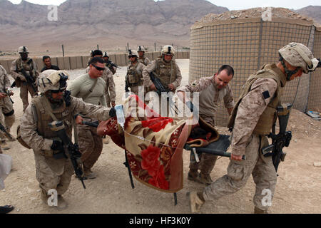 091101-M-8774P-017 HELMAND PROVINCE, Afghanistan (Nov. 1, 2009) Marines and Sailors assigned to India Company, 3rd Battalion, 4th Marine Regiment tend to the medical needs of an injured boy near forward operating base Golestan in Helmand Province, Afghanistan. The boy fell from an unknown height and was in critical condition. (U.S. Marine Corps photo by Lance Cpl. Chad J. Pulliam/Released) US Navy 091101-M-8774P-017 Marines and Sailors assigned to India Company, 3rd Battalion, 4th Marine Regiment tend to the medical needs of an injured boy Stock Photo
