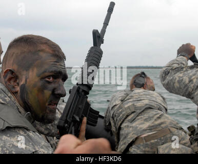New York Army National Guard Pvt. Mike Harris, a Tonawanda, N.Y. resident and infantryman with Troop C, 2nd Squadron, 101st Cavalry Regiment, prepares to enter the water of Lake Erie during a troop training exercise in Buffalo, N.Y., Sept 13, 2015. Harris, fulfilling the role of one of the teams two scout swimmers, was tasked with swimming to shore in advance of the F470 and providing security while the rest of the team. (US Army National Guard Photo by Spc. Alexander Rector) New York National Guard conduct Zodiac training 150913-Z-EL858-101 Stock Photo