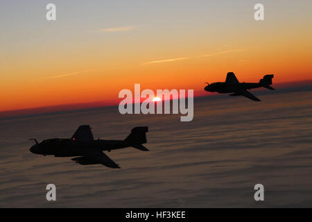 Two EA-6B Prowlers, belonging to 2nd Marine Aircraft Wing are silhouetted by a setting sun while conducting aerial maneuvers during an air-to-air refuel training exercise over the Atlantic Ocean Sept. 14, 2015. Aircraft from Marine Corps Air Station Cherry Point, N.C., were supported by Marine Aerial Refueler Transport Squadron 252 off the eastern Atlantic coast during the training exercise to hone their aerial refueling skills. VMGR-252 is the force multiplier for the Marine Air-Ground Task Force as it extends the operational reach of other aviation platforms under all weather conditions, day Stock Photo