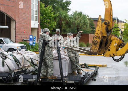 U.S. Soldiers from the Alpha Company, 218th Brigade Support Battalion, South Carolina Army National Guard deliver sandbags to the Columbia Riverfront Canal, Columbia, S.C., in an effort to repair the canal's breached levee during a statewide flood response, Oct. 5, 2015. The South Carolina National Guard has been activated to support state and county emergency management agencies and local first responders as historic flooding impacts counties statewide. Currently, more than 1,100 South Carolina National Guard members have been activated in response to the floods. (U.S. Air National Guard phot Stock Photo
