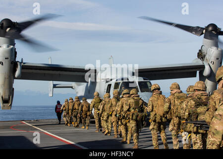 U.K. Royal Marines with 45 Commando board an MV-22B Osprey during a combined operation as part of exercise Blue Raptor aboard the U.K. Royal Navy’s HMS Ocean, Nov. 20, 2015. The Allied Maritime Basing Initiative is a proof-of-concept to provide the U.S. and NATO allies a year-round, maritime-based crisis response force by leveraging the amphibious capabilities residing in Europe. (U.S. Marine Corps photo by Staff Sgt. Keonaona C. Paulo/Released) Blue Raptor 151120-M-EF955-066 Stock Photo