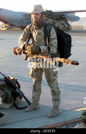 US Navy Corpsman Second Class Gartman, a member of Headquarters Company, Battalion Landing Team 3/6, 26th Marine Expeditionary Unit (Special Operations Capable) waits, with his Barrett M82A1 rifle, on the flightline at Kandahar International Airport, Kandahar, Afghanistan, prior to boarding a Marine Corps KC-130 on a mission in support of OPERATION ENDURING FREEDOM. The KC-130 is part of Marine Aerial Refueling Squadron VMGR-352. Navy Sniper M82 Stock Photo