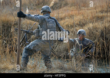 U.S. Army Spc. Cameron St. Onge with Charlie Company, 1st Battalion, 17th Infantry Regiment, 5th Stryker Brigade Combat Team, 2nd Infantry Division lends a helping hand to a fellow Charlie Company member, Pfc. Dustin Mesinhimer, while crossing a river during a joint patrol with soldiers from 2nd Battalion, 508th Parachute Infantry Regiment, 82nd Airborne Division in the Arghandab River Valley, Kandahar province, Afghanistan, Dec. 13, 2009. (U.S. Air Force photo by Master Sgt. Juan Valdes/Released) Flickr - DVIDSHUB - 5th SBCT, 2nd ID Troops Conduct Patrol in Arghandab River Valley Stock Photo