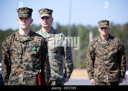 Cpl. Joseph Currey, left, stands in front of Lt. Col. Jeremy Winters , center, and Sgt. Maj. Jeffrey Durham after receiving an award at Marine Corps Air Station Cherry Point, N.C., March 1, 2016. Currey was awarded the Navy and Marine Corps Commendation Medal for his actions after witnessing an ambulance wreck. Currey demonstrated his devotion to serving others as he placed the well-being of the injured personnel above his own by running towards the scene of an accident and rendering aide to those need. Currey is an air support operations operator with Marine Aviation Support Squadron 1. Winte Stock Photo