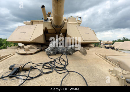 Army Pfc. Harlan Troutman, with the Tennessee Army National Guard’s H Troop, 2nd Squadron, 278th Armored Cavalry Regiment, scrambles into the driver’s compartment of an M1A1 Abrams tank to hook up an impact wrench while he and his crew race against the clock to replace two sections of track on the tank while competing in the Gen. Gordon Sullivan Cup best tank crew competition at Fort Benning, Ga., Tuesday, May 3, 2016. The Sullivan Cup tests tank crews from throughout the Army on everything from gunnery to mounted land navigation, maintenance and combat casualty care in a variety of physically Stock Photo