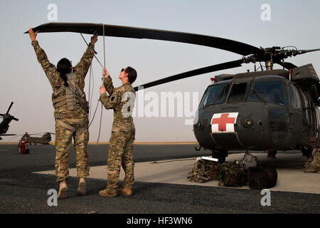 Capt. Elizabeth Mondo and Chief Warrant Officer 2 Megan Yanacek from Company F, 2nd Battalion, 238th Aviation Regiment, 40th Combat Aviation Brigade, finish a mission aboard a UH-60 Black Hawk Helicopter at Camp Buehring, Kuwait, March 28. They were part of an all-female round-flight from Camp Buehring to Camp Arifjan. (U.S. Army Photo by Staff Sgt. Ian M. Kummer, 40th Combat Aviation Brigade Public Affairs) Woman warriors deploy with the 40th CAB 160328-Z-JK353-025 Stock Photo