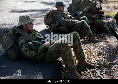 U.S. Marines with 1st Battalion, 1st Marine Regiment, and members of the Australian Army with 5th Battalion, Royal Australian Regiment, rest on the side of the road before simulating the transportation of a casualty victim outside Robertson Barracks, Darwin, Australia, May 12, 2016. U.S. Marines worked together with the Australian service members during Subject One for Corporal Class #0245. Experiencing Subject One for Corporal Class #0245 together allows everyone to train and learn from each other during Marine Rotational Force – Darwin (MRF-D).   MRF-D is a six-month deployment of Marines in Stock Photo